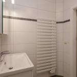 Badezimmer mit Waschbecken, Spiegelschrank und Heizkörper.