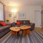 Wohnzimmer mit zwei Sofas, Holztisch und Blumen.