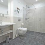 Badezimmer mit Dusche, Waschbecken und Toilette