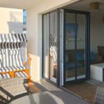 Terrasse mit Strandkorb und Glastür zum Wohnbereich