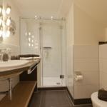 Badezimmer mit Dusche, Waschbecken und Toilette.