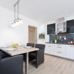 Essbereich mit Tisch und Stühlen. Küche mit Arbeitsplatte und Geräten.
