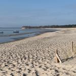 Strand mit Booten und Dünen im Hintergrund