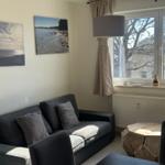 Ein Wohnzimmer mit Sofa, Fenster und Wandbildern.