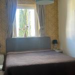 Schlafzimmer mit Bett, Fenster und Wandtapete.