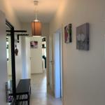 Flur mit Lampen, Bildern und Schuhschrank. Türen zu weiteren Räumen.