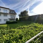 House with balconies and green garden area.