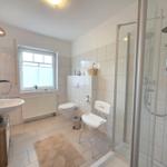 Badezimmer mit Dusche, Toilette und Waschbecken.