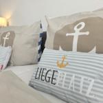 Bettkopfteil mit Kissen in Marineoptik und Wandlampe