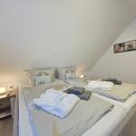 Bedroom with double bed, nightstand, and wall pictures