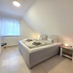 Bedroom with double bed, nightstand, and wardrobe. Window with curtains.