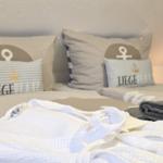 Bed head with pillows, with robe and towel below.