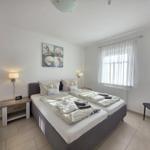 Bedroom with double bed, nightstand, window, and chair.