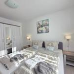 Bedroom with double bed, wardrobe, and wall art with shells.