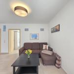 Living room with sofa, table, and pictures on the wall.