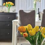 Table with chairs and tulip flowers in dining area