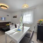 Living and dining area with sofa, dining table, and TV.