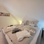 Bedroom with double bed, nightstand, and wall art