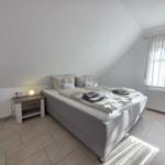 Bedroom with double bed, nightstand, and window with blinds.