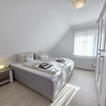 Bedroom with double bed, nightstand, and wardrobe. Window with curtains.