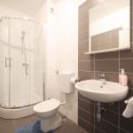 Badezimmer mit Dusche, Toilette und Waschbecken.