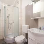 Badezimmer mit Dusche, Waschbecken und Toilette.