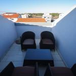 Terrasse mit vier Sitzgelegenheiten und Blick auf Dächer.