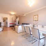 Wohn- und Essbereich mit Esstisch, Sofa und Wendeltreppe.