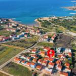 Luftbild eines Küstenorts mit roten Dächern und blauem Meer