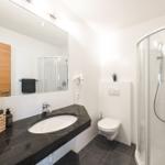 Badezimmer mit Dusche, Waschtisch, WC und Haarfön