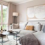 Wohnzimmer mit Sofa, Tisch und Fenster mit Blick auf Grün.