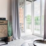 Wohnzimmer mit TV, Schrank und Balkonansicht.