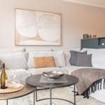 Wohnzimmer mit Sofa, Tischen und Wandbild