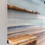 Wand mit Strandmotiv, Korbregal und Korb unten