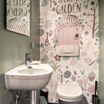 Badezimmer mit Waschbecken, Toilette und gemustertem Wandbehang.