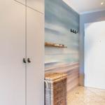 Eingangsbereich mit Garderobe, Wandbild und Korb.