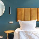 Schlafzimmer mit Bett, Kopfteil und Wandspiegel