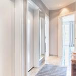 Flur mit Türen, Teppich und Korb. Durchgang zu Wohnbereich mit Balkontür.