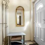 Entrance area with mirror, coat rack, and bench with blankets.