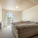 Bedroom with bed, door to balcony, and wooden ceiling.