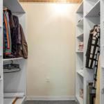 Large closet with multiple shelves and clothing.