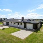 Single-family house with garage and garden. Backyard with forest and clear sky.