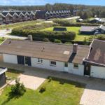 Single-family house with garage and garden. Several houses and trees are visible in the background.