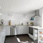 Kitchen with white cabinets, stainless steel sink, and window to terrace.