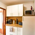 Küche mit Kühlschrank, Mikrowelle und Kaffeemaschine.