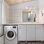 Bathroom with washing machine, mirror, and window.