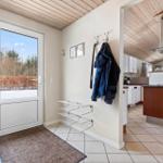 Entrance with door, hooks, and view into the kitchen.