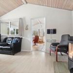 Living room with fireplace, leather sofa, and view into the kitchen.