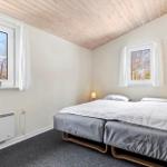 Bedroom with double bed, two windows, and wooden ceiling.