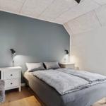Schlafzimmer mit Doppelbett, zwei Nachttischen und einer Glastür.